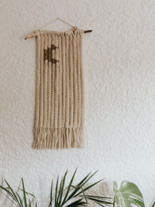 This charming little wall hanging uses two different coloured ropes and sennets of square knots to create an image of a crescent moon.  Made on a treated piece of driftwood foraged in Cape Town.