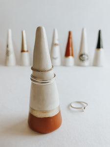 Store and display your favourite rings with this Sienna Base ring cone. It's such a beautiful addition to your space, adding a touch boho magic! Made with air dry clay, painted with sienna and gold acrylic paint and sealed with a high gloss coating to make it water resistant.