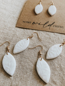 Handmade white polymer clay dangle leaf earrings with gold nickel free jewellery components.