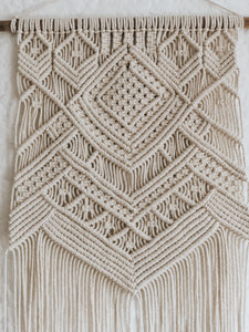 This hanging has a beautifully complex yet simple design, using diagonal double half hitch knots to create texture. Made with natural 3mm cotton rope on a wooden dowel rod.