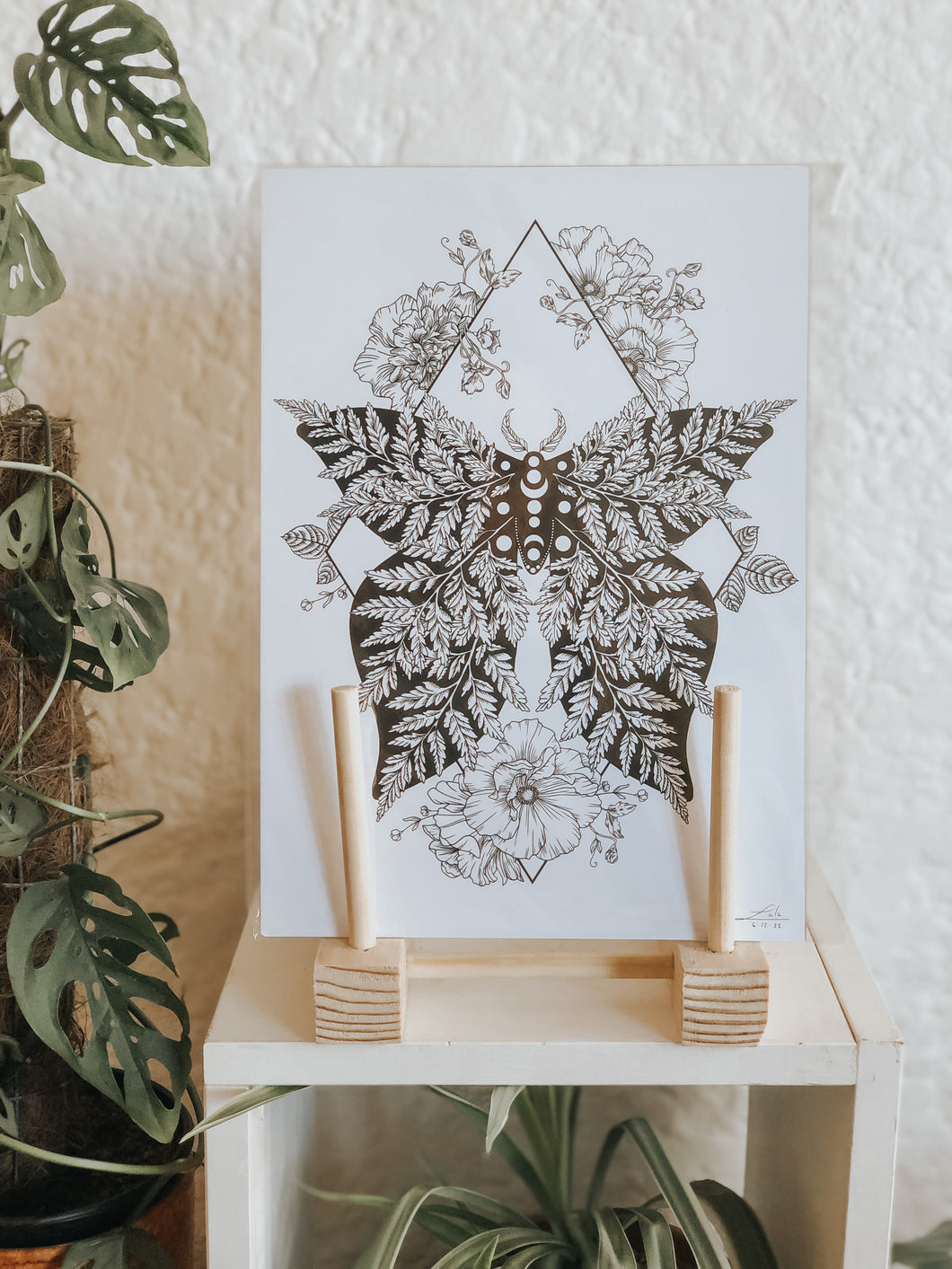 Black and white line work of a moth surrounded by botanicals. Simply download, print, frame and enjoy!