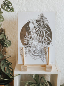 Black and white illustration of a bong surrounded by a cannabis plant and botanicals with black background. Pair your prints with other illustrations to create a whimsical story of your own.