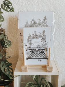 Black and white illustration of a typewriter surrounded with botanicals. The message reads "you're fucking beautiful." Pair your prints with other illustrations to create a whimsical story of your own.