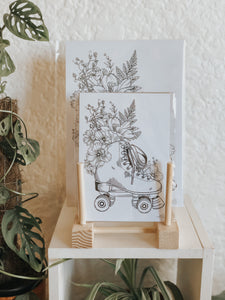 Black and white line work of a pair of roller skates surrounded with botanicals. Simply download, print, frame and enjoy!