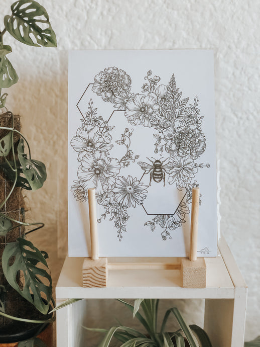 Black and white illustration of botanicals, hexagons and a sweet little bee. Pair your prints with other illustrations to create a whimsical story of your own.