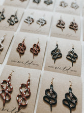 Modern handmade polymer clay snake earrings with a bohemian witchy aesthetic. Each snake is hand rolled and small details are painted with gold acrylic paint and have gold nickel free jewellery components.