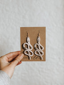 Modern handmade polymer clay snake earrings with a bohemian witchy aesthetic. Each snake is hand rolled and small details are painted with gold acrylic paint and have gold nickel free jewellery components.